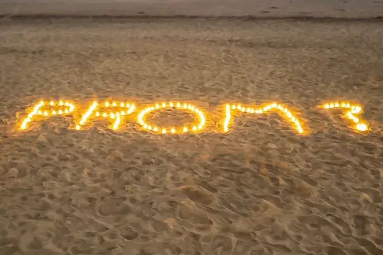 Candles on a beach used to create a high school promposal.